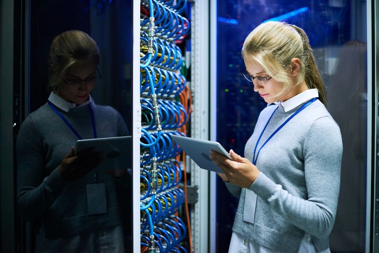 Portrait of young smiling woman checking data on digital tablet while working